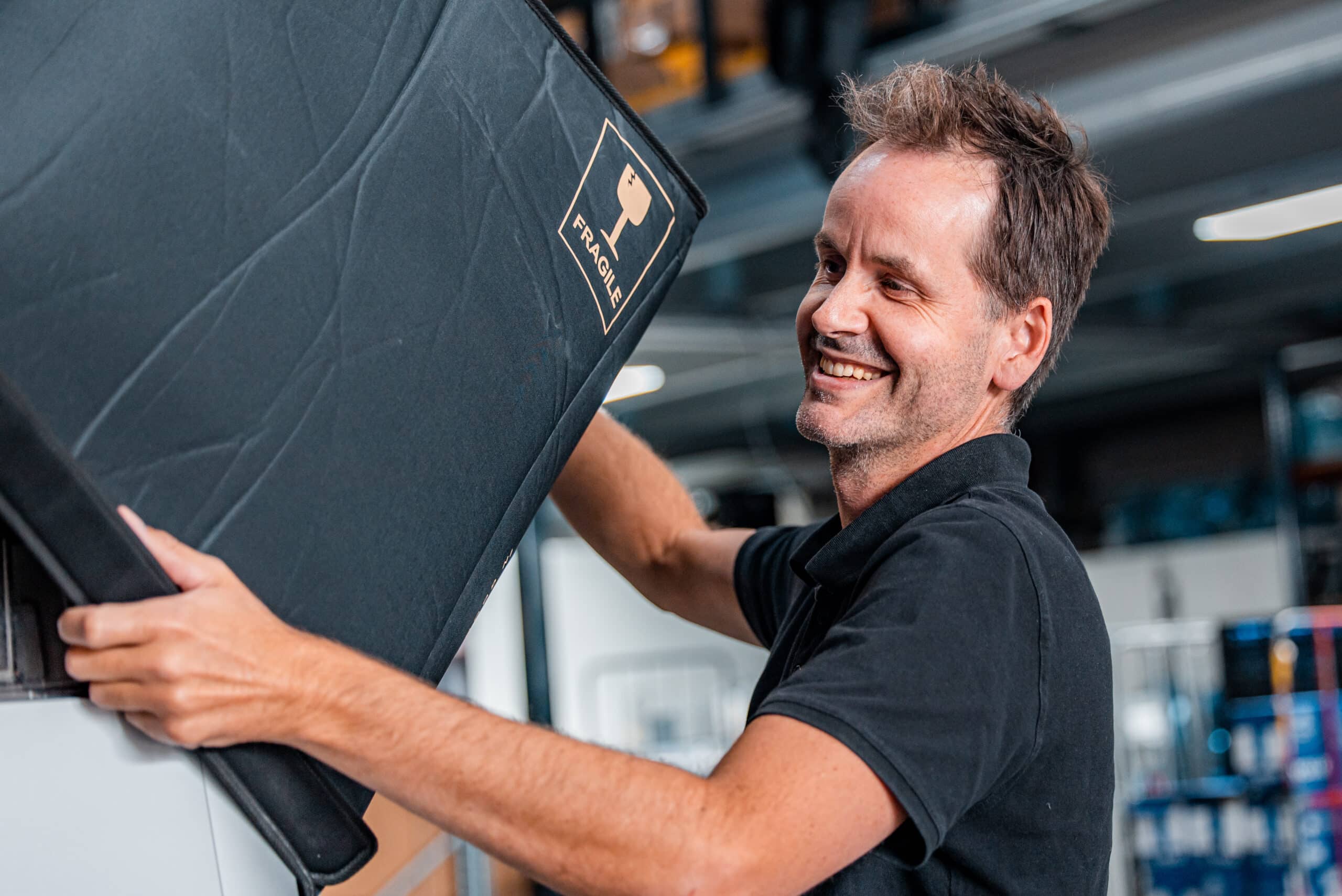 Collega Etienne van logistiek met een koffiemachine in het magazijn