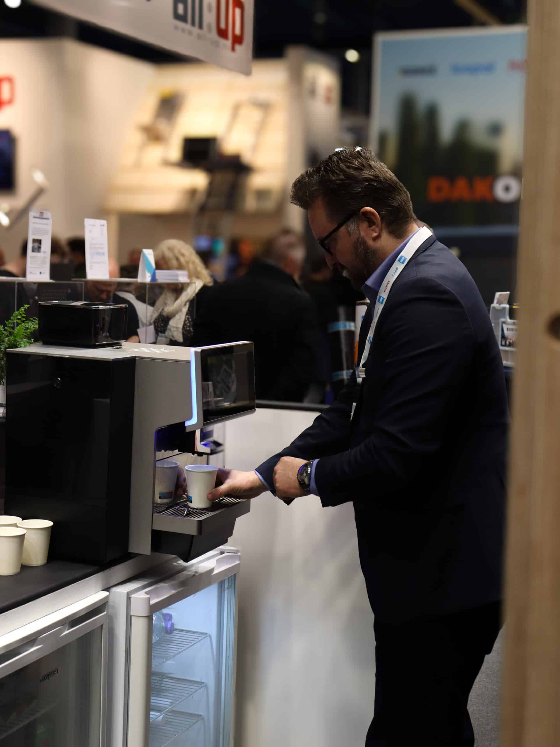 Beursstand waar bezoekers koffie krijgen bij een Bar Company koffiemachine