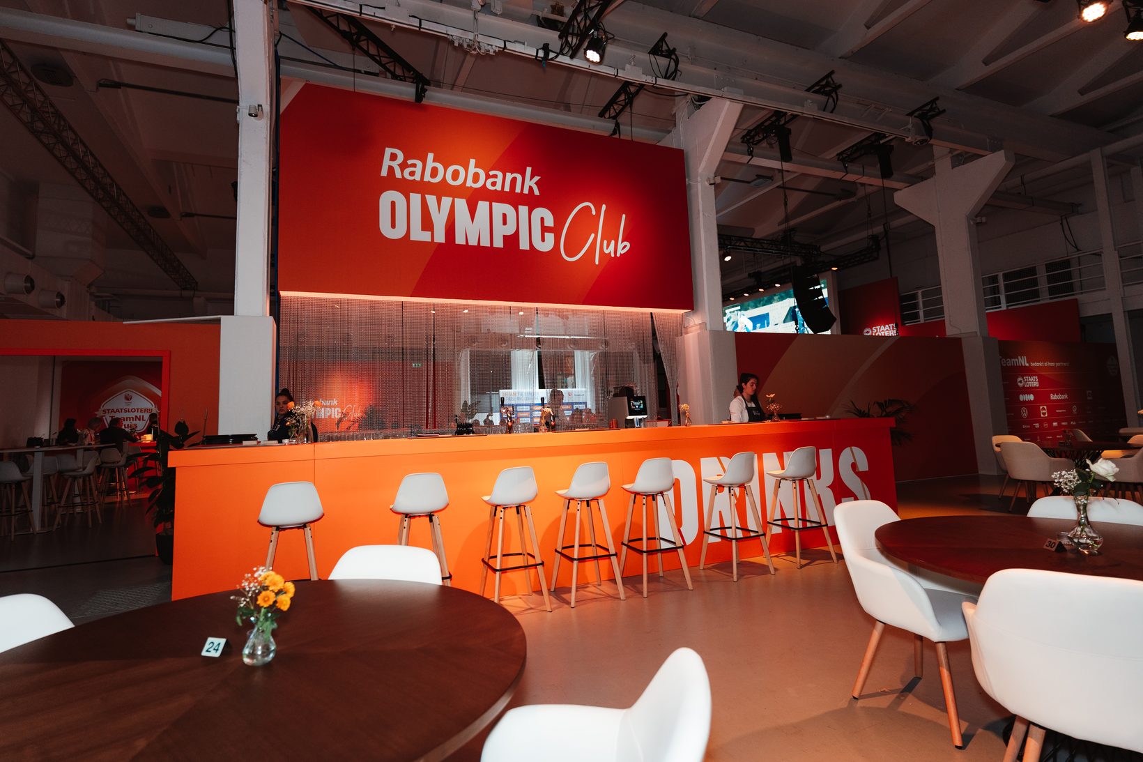Bar van de Rabobank Olympic Club in het Staatsloterij TeamNL Huis in Milaan, met een koffiemachine op de oranje bar