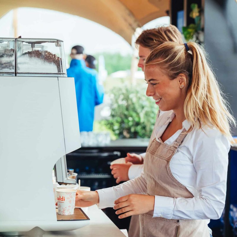 Koffiemachine in gebruik tijdens evenement met vrolijke barista